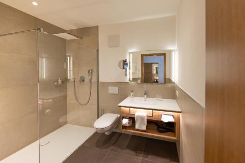 a bathroom with a sink and a shower and a toilet at Hotel Restaurant Zur Linde in Erbach
