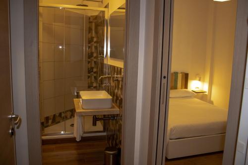a bedroom with a bed and a bathroom with a sink at B&B JONIO Roma in Rome