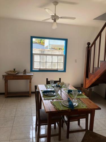 uma sala de jantar com uma mesa e uma ventoinha de tecto em Casa aconchegante em bairro nobre da cidade Paraty em Paraty