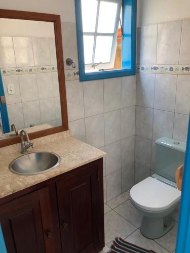 a bathroom with a sink and a toilet and a mirror at Casa aconchegante em bairro nobre da cidade Paraty in Paraty