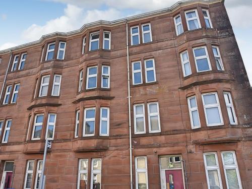 an old red brick building with white windows at John Muir Apartment in Helensburgh