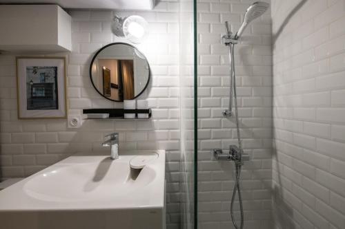 een badkamer met een wastafel en een douche met een spiegel bij Le Gatsby Superbe cocon cosy proche place in Lyon