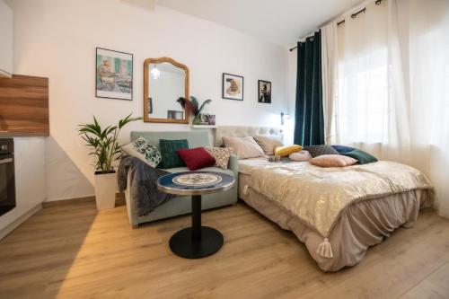 een slaapkamer met een bed, een bank en een spiegel bij Le Gatsby Superbe cocon cosy proche place in Lyon