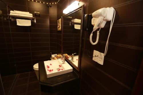 a bathroom with a sink and a mirror and a toilet at Kawasaki Hotel Cầu Giấy in Hanoi