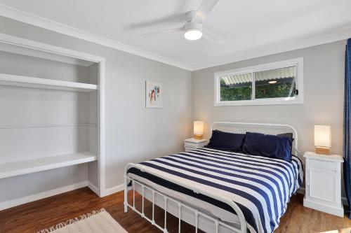 a bedroom with a bed with blue and white stripes at Cylinder View 10A Yarrong in Point Lookout