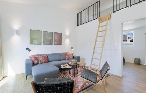 a living room with a blue couch and a ladder at Amazing Home In Lembruchdümmer See in Lembruch