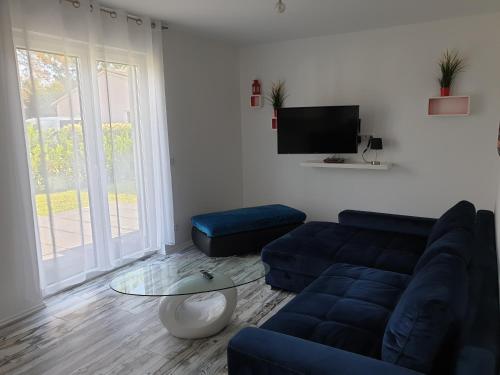 a living room with a blue couch and a table at Ferienwohnung mit Terrasse in Neustrelitz