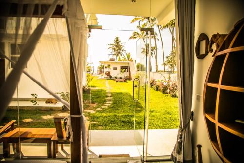 a room with a sliding glass door with a view of a yard at Infinity of Sri Lanka in Paiyagala South