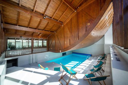 an indoor swimming pool with chairs in a house at Hotel Vilagaros in Garós