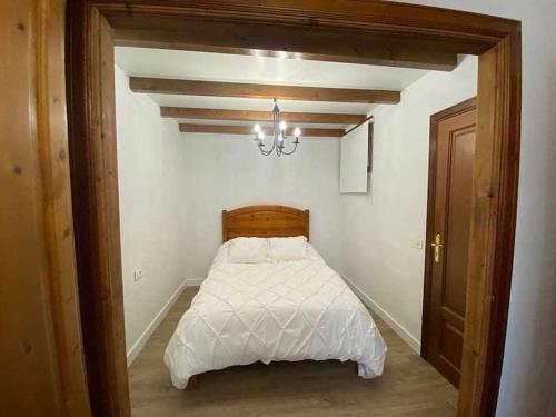 a bedroom with a white bed with a chandelier at Teide Hideaway in Vilaflor