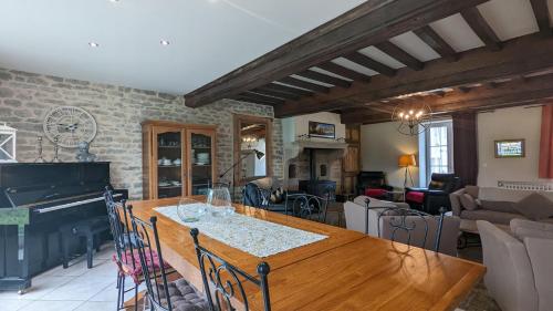 - un salon avec une table en bois et un piano dans l'établissement Le Moulin de la Motte, à Bellenot-sous-Pouilly