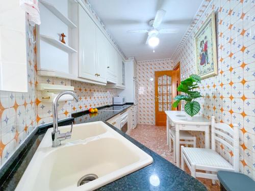 cocina con fregadero y mesa en Apartamento NINA, 3 hab, 2 baños, playa, a/a,6 pers, en Salou