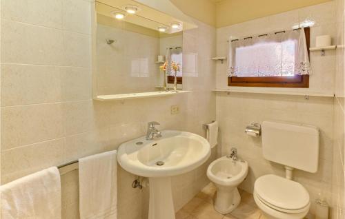 een witte badkamer met een wastafel en een toilet bij Amazing Apartment In Carcegna Di Miasino No With Kitchen in Pettenasco