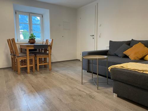 uma sala de estar com um sofá e uma mesa em Ferienwohnung Kaffeeduft em Reutte