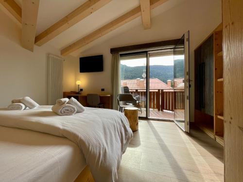 een slaapkamer met een bed en uitzicht op een balkon bij Hotel Stella Alpina in Andalo