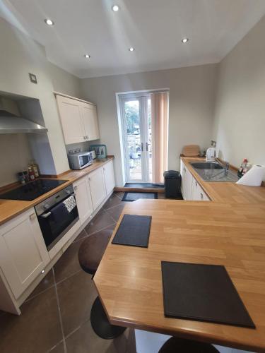 a kitchen with white cabinets and a wooden table at St Annes in Halifax