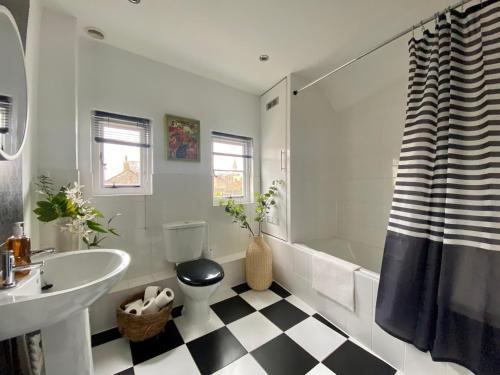 bagno con pavimento a scacchi in bianco e nero di Historic Family Cottage - Central Frome a Frome