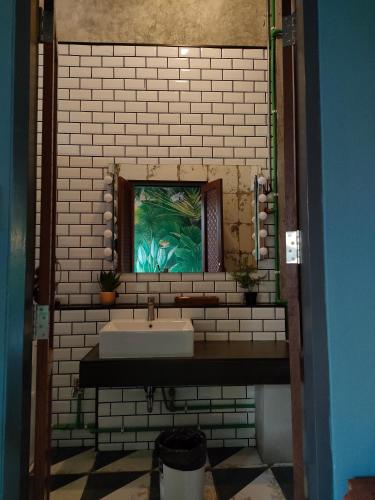 a bathroom with a white sink and a window at โรงแรม บอร์ดดิ้งเฮ้าส์ in Ban Bang Yai Chuai