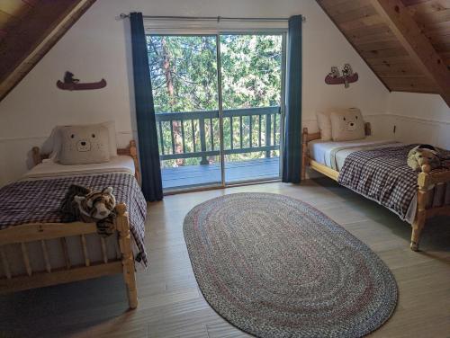 a bedroom with two beds and a large window at Breckenridge Chalet near Yosemite. Dog friendly! in Groveland