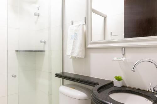 a bathroom with a toilet and a sink and a mirror at Merepe Residence in Porto De Galinhas