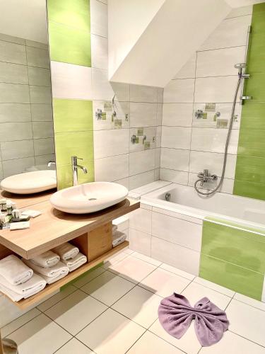 a bathroom with a sink and a tub and a toilet at Hotel Restaurant Le Petit Kohlberg in Lucelle
