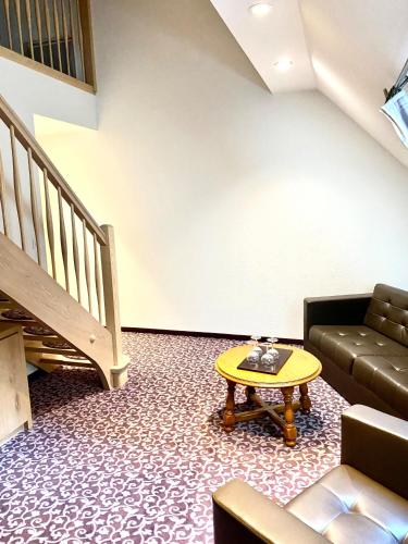 a living room with a couch and a table at Hotel Restaurant Le Petit Kohlberg in Lucelle