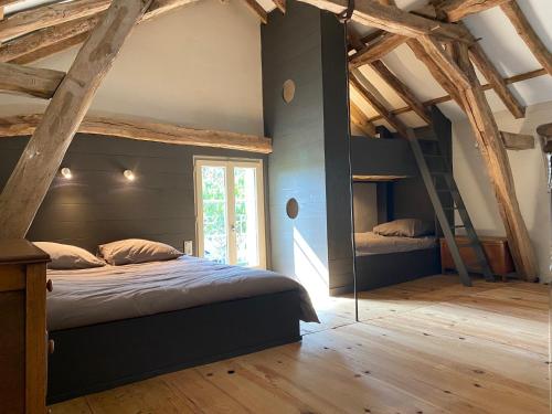 a bedroom with two bunk beds and a ladder at Gîte Dordogne Périgord in Hautefort