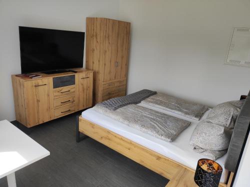 1 dormitorio con 1 cama y TV de pantalla plana en Ferienwohnung Morgensonne, en Bad Feilnbach