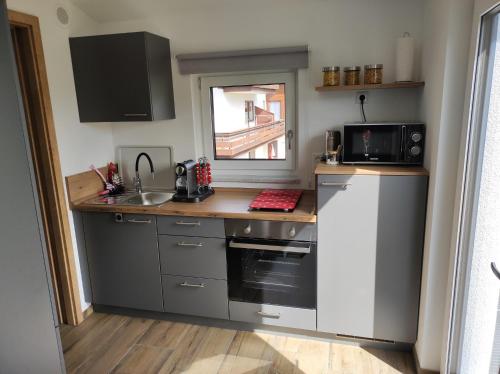 a small kitchen with a sink and a microwave at Ferienwohnung Morgensonne in Bad Feilnbach