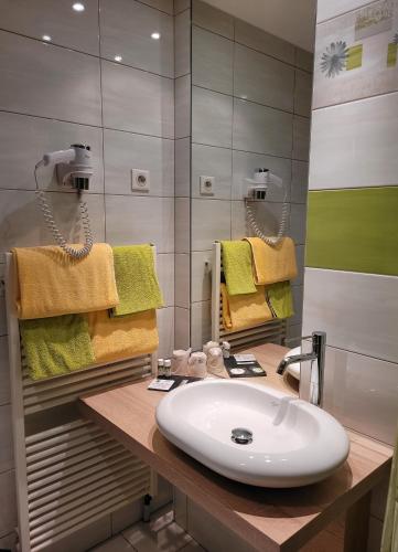 a bathroom with a sink and a mirror at Hotel Restaurant Le Petit Kohlberg in Lucelle