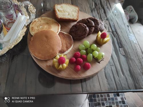 un plato de comida con tortitas y fruta en una mesa en Belle suite parentale 