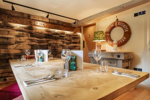 a wooden table with wine glasses and a mirror at The George Hotel, Dorchester-on-Thames, Oxfordshire in Dorchester on Thames