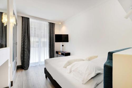 a white bedroom with a bed and a window at Magnifique appartement - 2BR - 6P - Place de l'Etoile in Paris