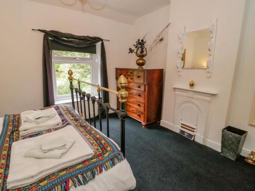 a bedroom with a bed and a fireplace and a mirror at 26 Llawr Pentre in Colwyn Bay