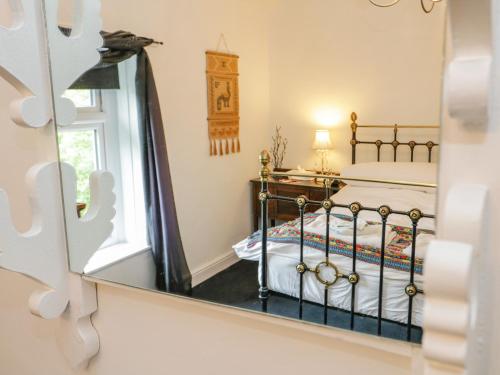 a bedroom with a bed and a mirror at 26 Llawr Pentre in Colwyn Bay