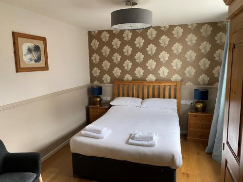 um quarto com uma cama com duas toalhas em The Bullshead, Arthingworth House B&B em Market Harborough