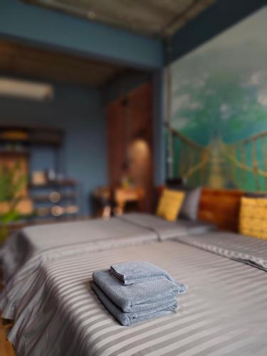 a pile of towels sitting on top of a bed at โรงแรม บอร์ดดิ้งเฮ้าส์ in Ban Bang Yai Chuai