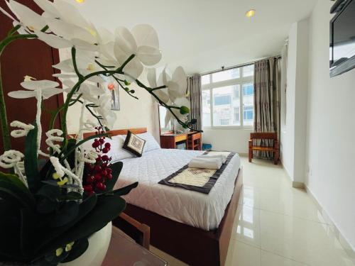 een slaapkamer met een bed met witte bloemen erop bij SaiGon Europe Hotel in Ho Chi Minh-stad