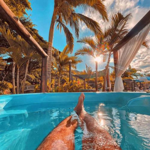 two people laying in a swimming pool at a resort at Mata Atlântica Park Hotel in Matinhos