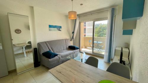 ein Wohnzimmer mit einem Sofa und einem Tisch in der Unterkunft Superbe studio en hyper centre in Cavalaire-sur-Mer