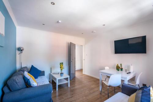 a living room with a blue couch and a table at The Douglas - Spacious 2 bed apartment in Uddingston in Uddingston