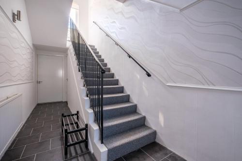 a staircase in a building with a white wall at The Douglas - Spacious 2 bed apartment in Uddingston in Uddingston