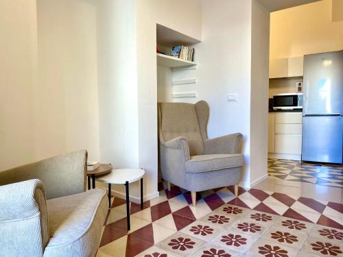 a living room with two chairs and a kitchen at Dimore San Giovanni - Puglia Mia Apartments in Monopoli