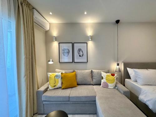 - un salon avec un canapé et des oreillers jaunes dans l'établissement Kono Studios & Suites, à Thessalonique
