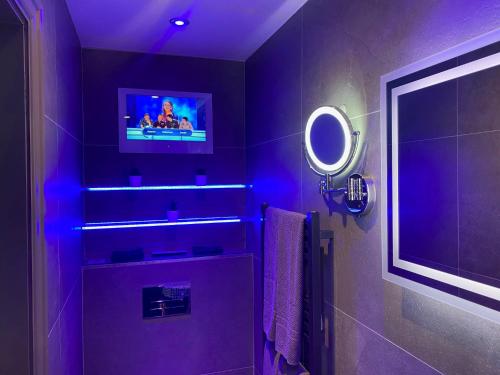 a purple bathroom with a tv on the wall at The Sawley Arms in Ripon