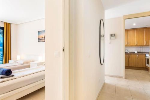 a white room with a bed and a kitchen at Bright and welcoming holiday home in Puerto de Santiago