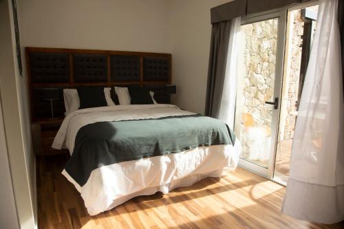 a bedroom with a large bed and a large window at Rozas Apart in Ezeiza