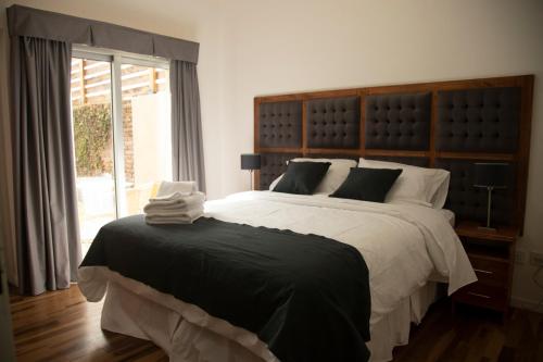 a bedroom with a large bed and a window at Rozas Apart in Ezeiza