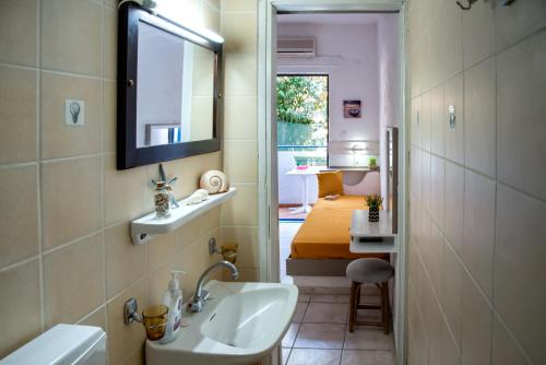 阿齊亞佩拉加的住宿－亞馬遜公寓式酒店，一间带水槽和镜子的浴室以及一间卧室