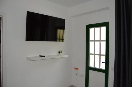 un televisor en una pared junto a una ventana en Casa Rural Guadá, en Valle Gran Rey